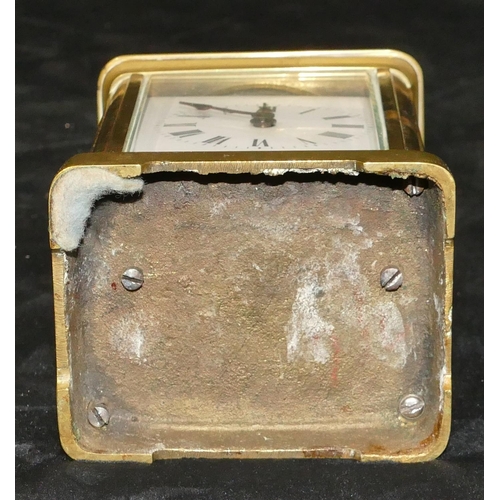 777 - A brass carriage clock with swing overhead handle, white enamel dial with Roman numerals (with key),... 