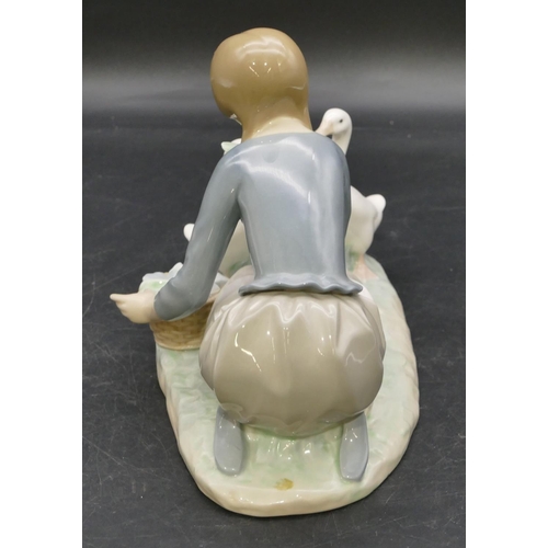 78 - A Lladro group of a kneeling young lady feeding 2 birds, 23.5cm wide.