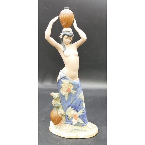 79 - A Nadal glazed earthenware figure of half naked lady holding a jug on her head, 39cm high.