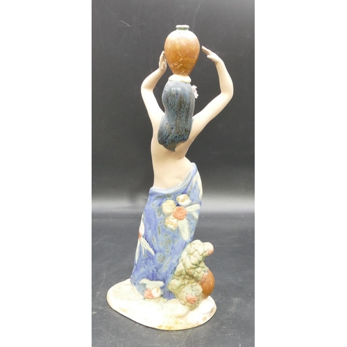 79 - A Nadal glazed earthenware figure of half naked lady holding a jug on her head, 39cm high.