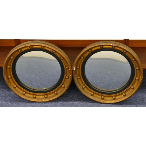 810 - A pair of gilt plaster circular convex wall mirrors with inner ball motifs and black reeded rims, 43... 