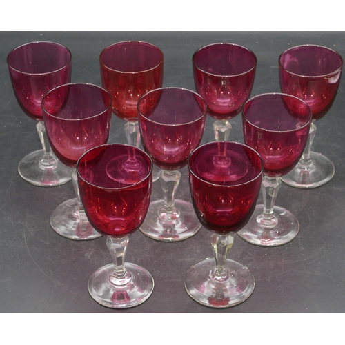 95 - A set of 9 ruby and clear drinking glasses with hexagonal stems on round bases, 13cm high.