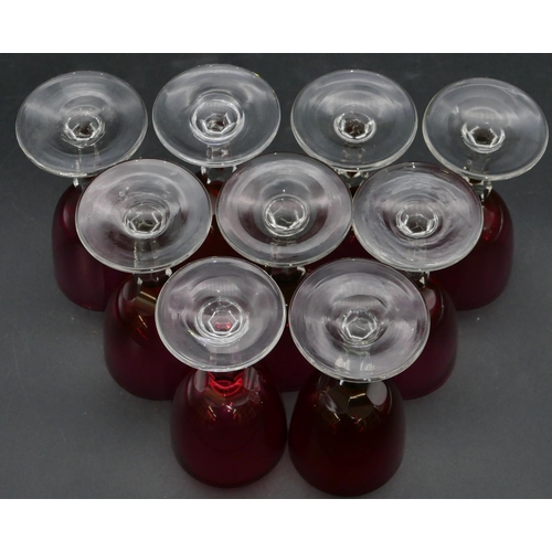 95 - A set of 9 ruby and clear drinking glasses with hexagonal stems on round bases, 13cm high.