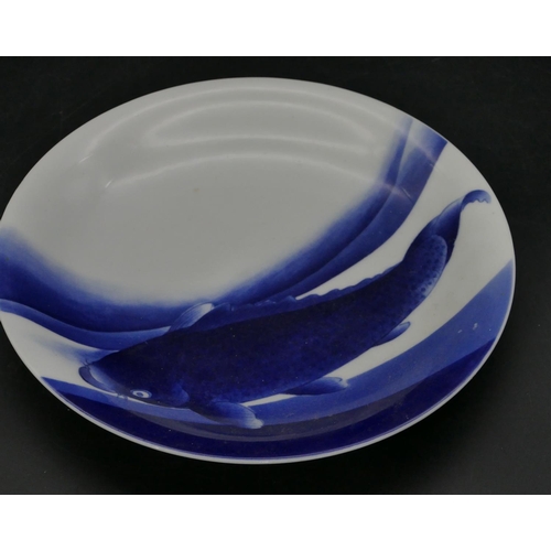 97 - An Oriental blue and white round plate with carp decoration, 24.2cm diameter (slight chip to rim).