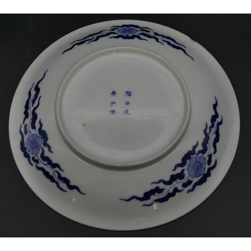 97 - An Oriental blue and white round plate with carp decoration, 24.2cm diameter (slight chip to rim).