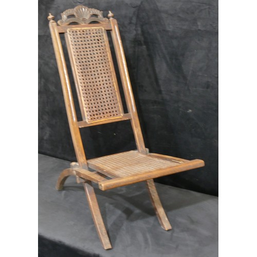 822 - A walnut folding steamer chair with bergere seat and part back, carved shell and scroll motif