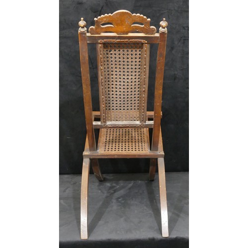 822 - A walnut folding steamer chair with bergere seat and part back, carved shell and scroll motif