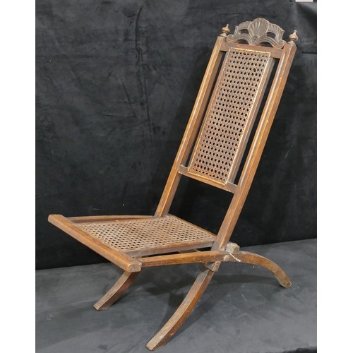 822 - A walnut folding steamer chair with bergere seat and part back, carved shell and scroll motif