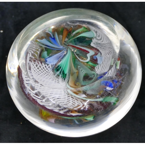 117 - A glass paperweight with inner multi-coloured twist and scroll decoration, 7cm diameter.