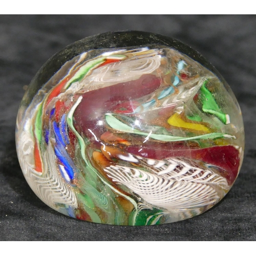 117 - A glass paperweight with inner multi-coloured twist and scroll decoration, 7cm diameter.