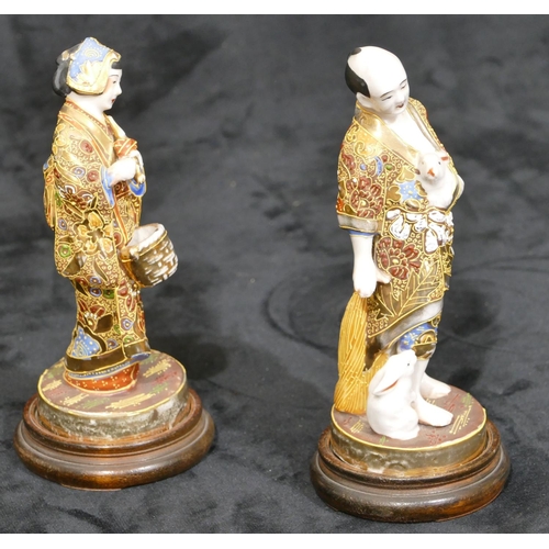 34 - A pair of Oriental figures of gentleman and lady with allover gilt decoration, on round wooden  base... 