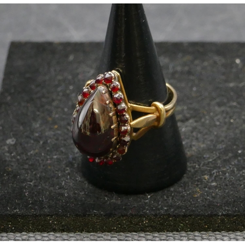 409 - A gold ladies cluster ring with centre pear shaped garnet, surround by smaller garnets, Size P, 6.3 ... 