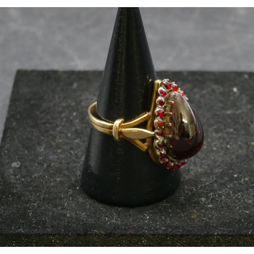 409 - A gold ladies cluster ring with centre pear shaped garnet, surround by smaller garnets, Size P, 6.3 ... 