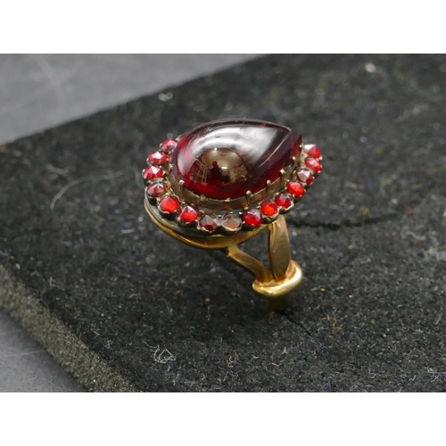 409 - A gold ladies cluster ring with centre pear shaped garnet, surround by smaller garnets, Size P, 6.3 ... 