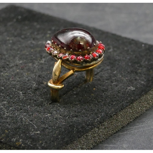 409 - A gold ladies cluster ring with centre pear shaped garnet, surround by smaller garnets, Size P, 6.3 ... 