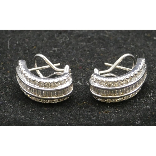 417 - A pair of 18ct white gold half hoop earrings, each set with 22 baguette cut diamonds (estimated weig...