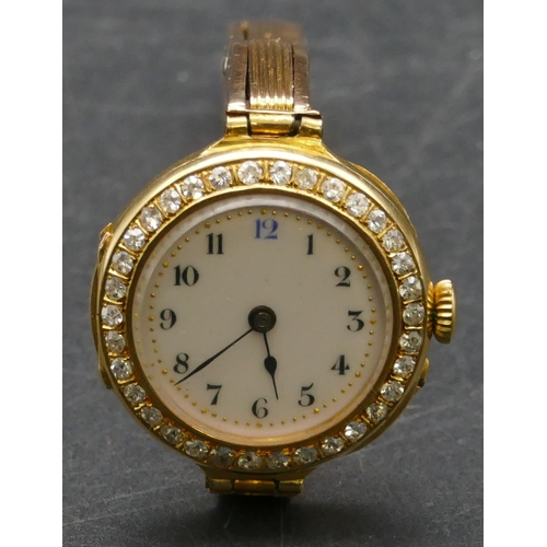 463 - An 18ct gold circular wristwatch with white enamel dial and Arabic numerals all surrounded by 34 dia...