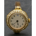 An 18ct gold circular wristwatch with white enamel dial and Arabic numerals all surrounded by 34 dia... 
