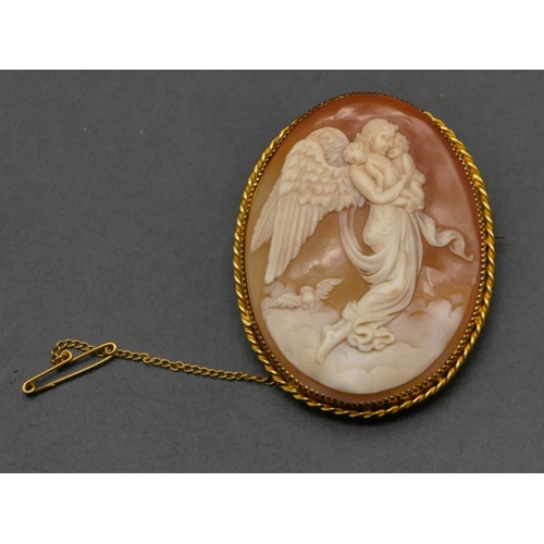 478 - A 9ct gold oval cameo depicting angel carrying 2 cupids, 5.4cm high, 17.9 grams gross.