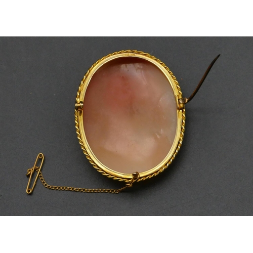 478 - A 9ct gold oval cameo depicting angel carrying 2 cupids, 5.4cm high, 17.9 grams gross.