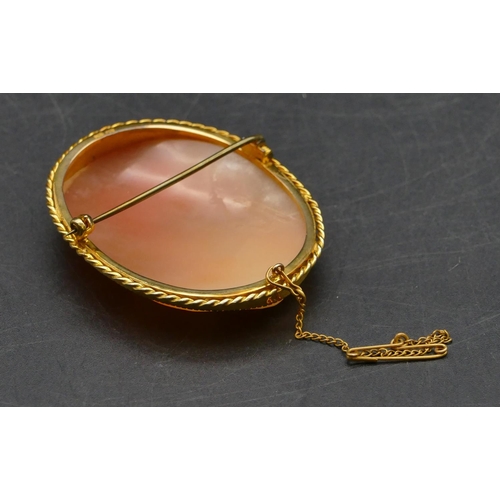 478 - A 9ct gold oval cameo depicting angel carrying 2 cupids, 5.4cm high, 17.9 grams gross.