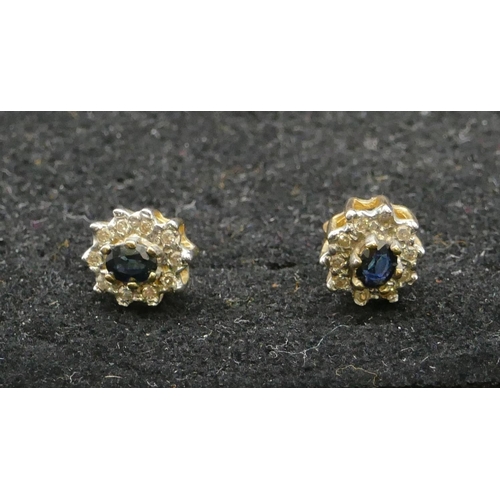 480 - A pair of 9ct gold oval cluster earrings set with centre sapphires and surrounded by small diamonds,... 