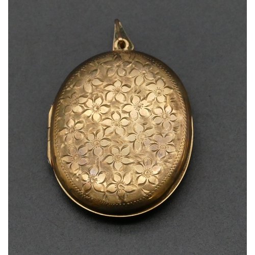 483 - A 9ct gold oval locket with engraved floral hinged front, 4.2cm high without clip, 12 grams gross.