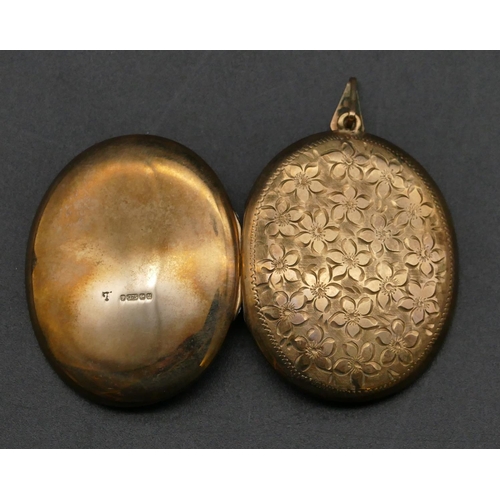 483 - A 9ct gold oval locket with engraved floral hinged front, 4.2cm high without clip, 12 grams gross.