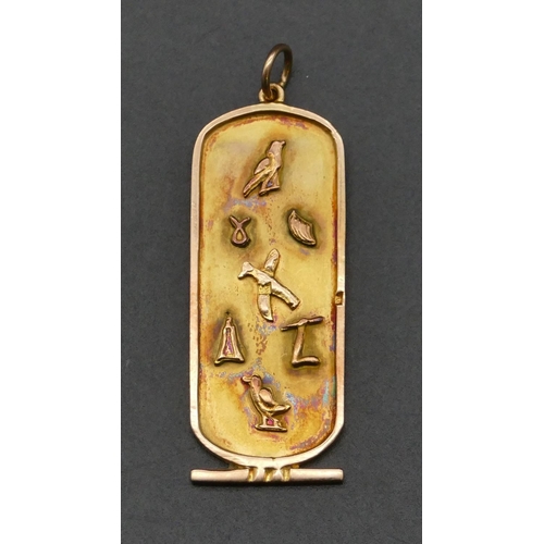 487 - An Eastern high carat gold rectangular shaped cartouche pendant with hieroglyphs of raised bird and ... 