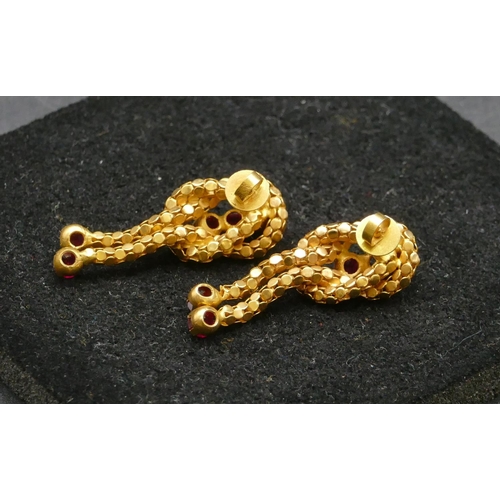 491 - A pair of Eastern high carat gold knot shaped earrings with drop tassels mounted with red stones (1 ... 