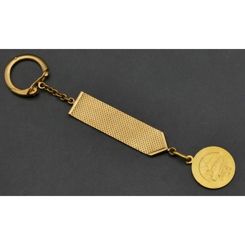 496 - An 18ct gold keyring with chased decoration, mounted with 18ct gold St. Christopher, 13.5cm long ove... 