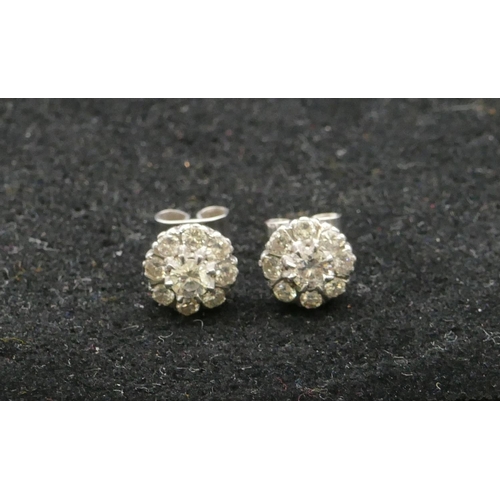 501 - A pair of platinum cluster earrings set with centre diamond (approx. 0.20ct) each surrounded by 8 sm... 