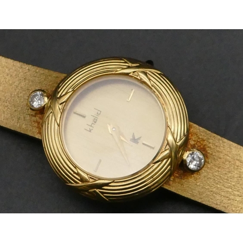 503 - An 18ct gold Khalid ladies circular wristwatch mounted with 2 diamonds, matching strap bracelet, 16.... 