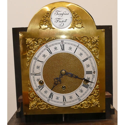 691 - A 1920's oak 8-day striking Westminster chime Grandmother clock with brass arched dial, Roman and Ar... 