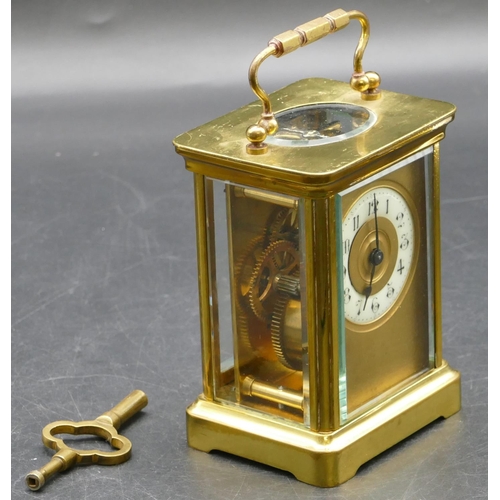 692 - A brass carriage clock with cream chapter ring with Arabic numerals, swing overhead handle (working)... 