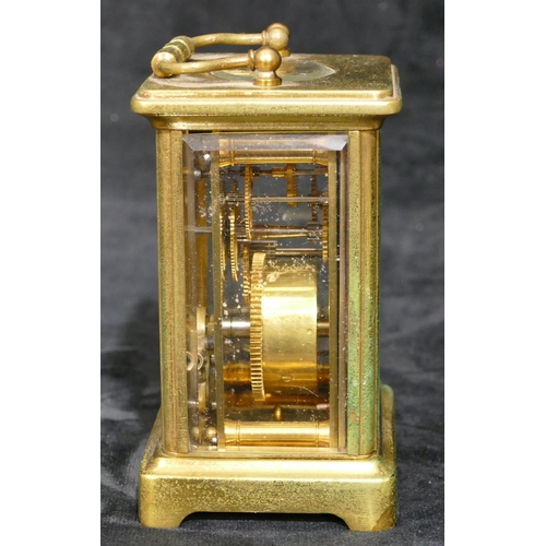 695 - A brass carriage clock with white enamel dial and Arabic numerals, swing overhead handle (over wound... 