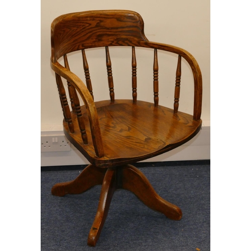 703 - An early 20th Century oak swivel desk chair with solid seat, turned finials, X-shaped base (no casto... 