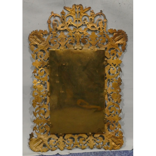 743 - A brass hanging bevelled wall mirror with pierced and raised figurehead, floral, leaf and scroll dec... 