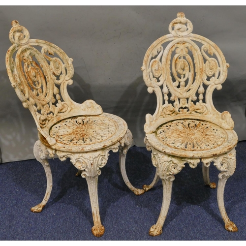 746 - A pair of Victorian white painted cast iron garden chairs with allover pierced and raised scroll and... 