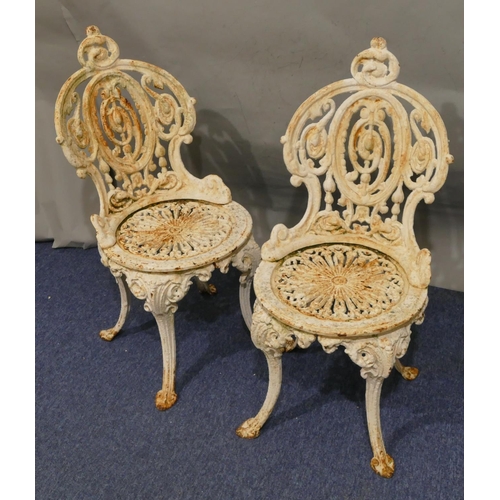 746 - A pair of Victorian white painted cast iron garden chairs with allover pierced and raised scroll and... 