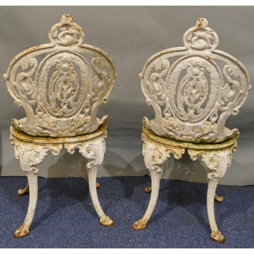 746 - A pair of Victorian white painted cast iron garden chairs with allover pierced and raised scroll and... 