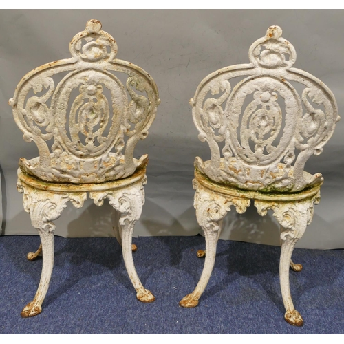 746 - A pair of Victorian white painted cast iron garden chairs with allover pierced and raised scroll and... 