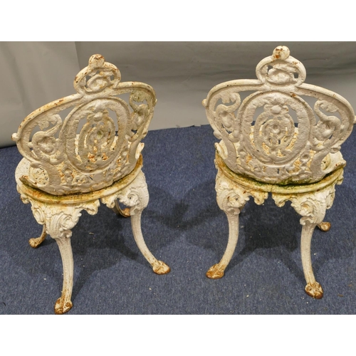 746 - A pair of Victorian white painted cast iron garden chairs with allover pierced and raised scroll and... 