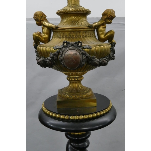 749 - A 19th Century ormolu and ebony standard lamp with urn motif and raised cupid, swag and floral decor... 