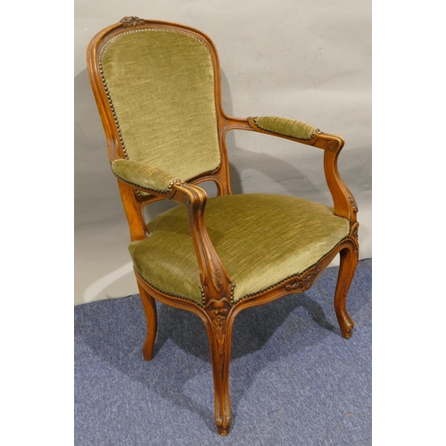 750 - A walnut fauteuil armchair with part carved floral and leaf motifs, green velvet overstuffed seat, b... 