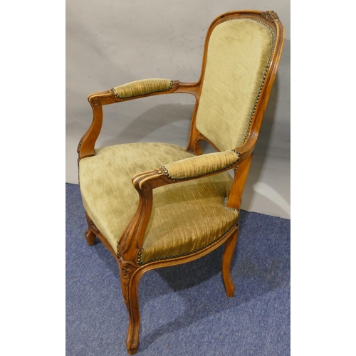 750 - A walnut fauteuil armchair with part carved floral and leaf motifs, green velvet overstuffed seat, b... 