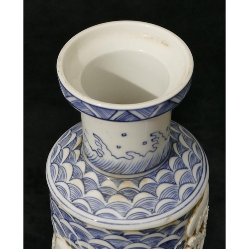 97 - An Oriental round bulbous thin necked trumpet shaped vase on blue and white ground with raised drago... 