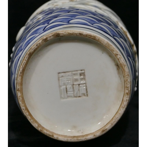 97 - An Oriental round bulbous thin necked trumpet shaped vase on blue and white ground with raised drago... 