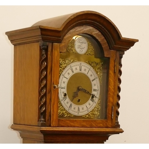 691 - A 1920's oak 8-day striking Westminster chime Grandmother clock with brass arched dial, Roman and Ar... 