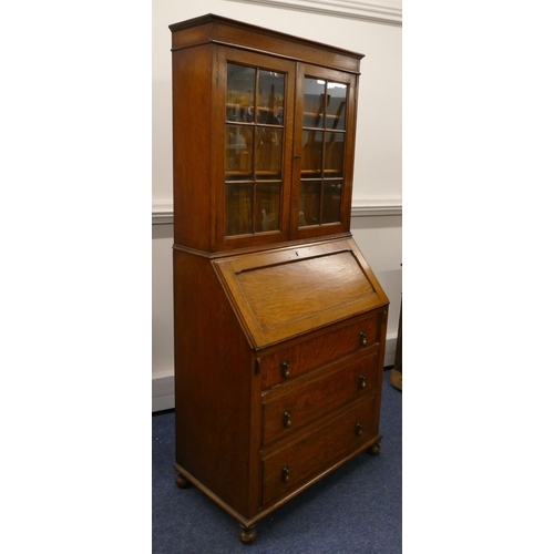 714 - A 1920/30's oak bureau bookcase with panelled glass doors above full front with pigeonholes and draw... 